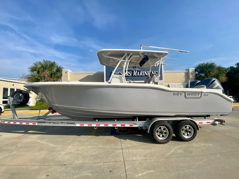 Slide: The Image of 2022 Key West 263 FS boat on a trailer in a parking lot. - 0