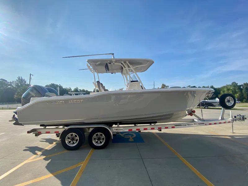 Slide: The Image of 2022 Key West 263 FS boat on a trailer in a parking lot. - 1