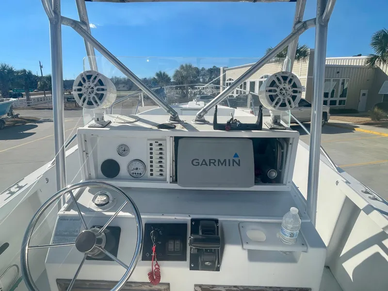 Slide: The Image of 1980 Robalo 2380 boat dashboard with Garmin navigation system and steering wheel. - 10