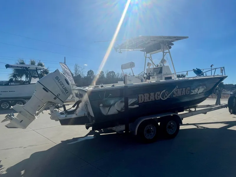 Slide: The Image of 1980 Robalo 2380 boat on trailer with Suzuki outboard motor in sunny outdoor setting. - 3