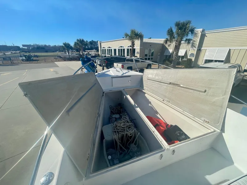 Slide: The Image of 1980 Robalo 2380 boat storage compartments open, revealing ropes and equipment. - 15