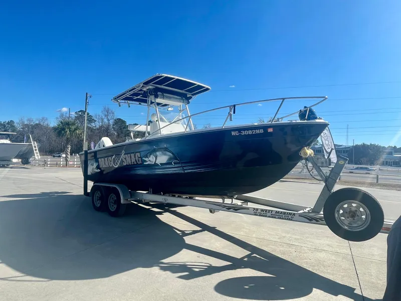 Slide: The Image of 1980 Robalo 2380 boat on a trailer under a clear blue sky. - 4