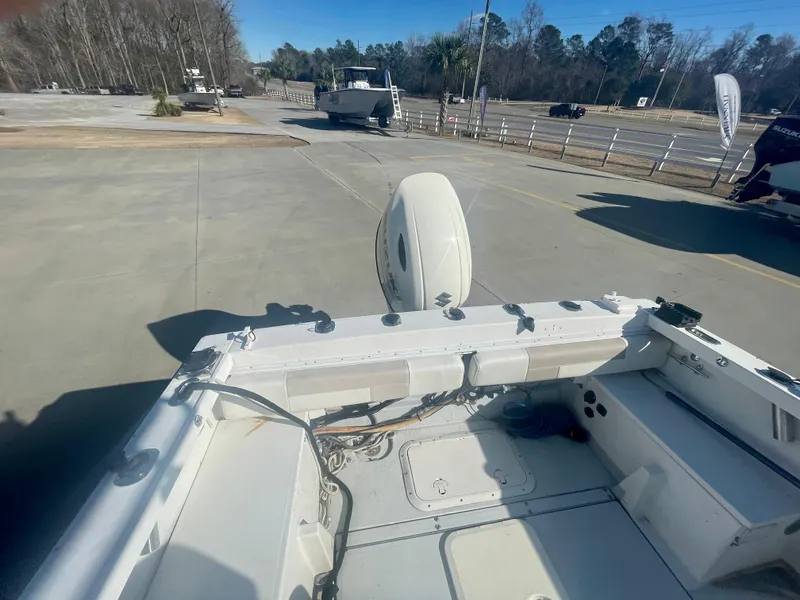 Slide: The Image of 1980 Robalo 2380 boat stern view with outboard motor in a parking lot. - 5