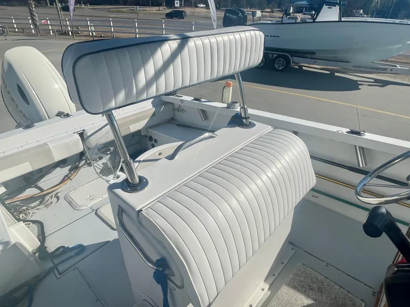 Slide: The Image of 1980 Robalo 2380 boat interior with white cushioned seating and steering wheel. - 9