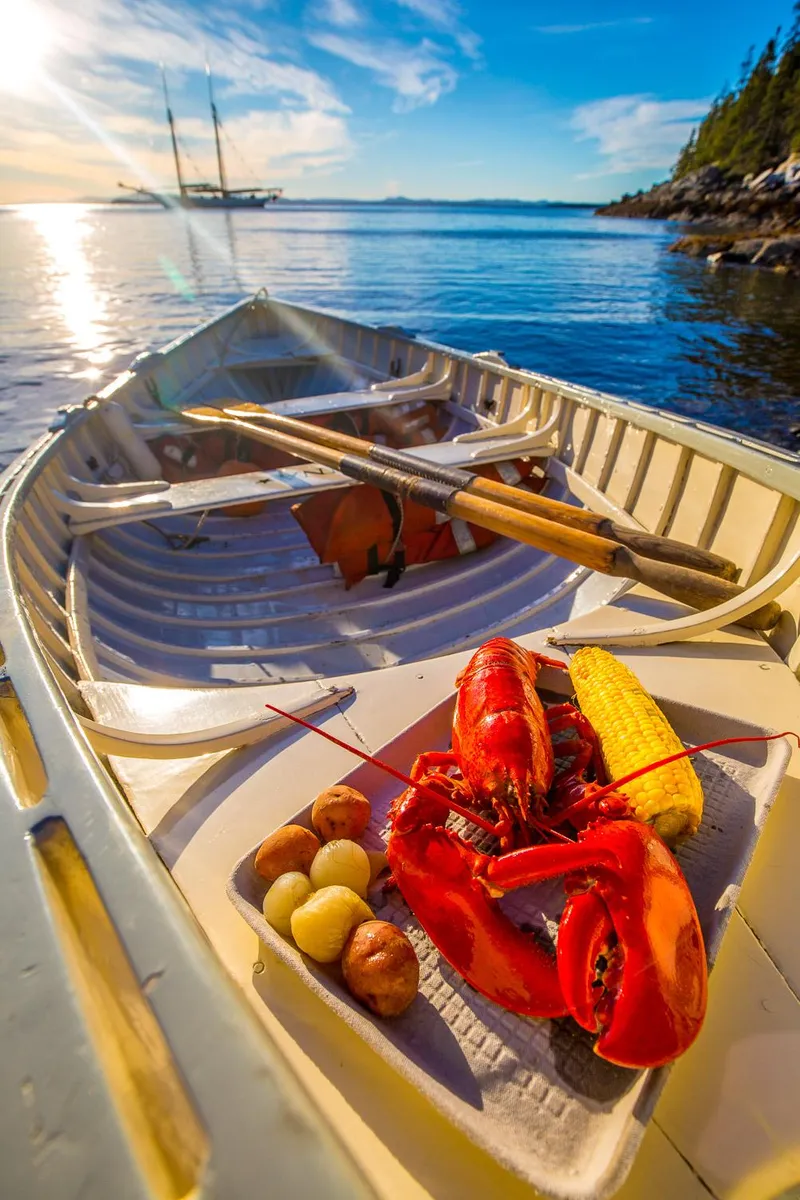 Slide: The Image of Rowboat with lobster meal, overlooking a 1962 Gamage Coastal Gaff Rigged Schooner at sunset. - 24
