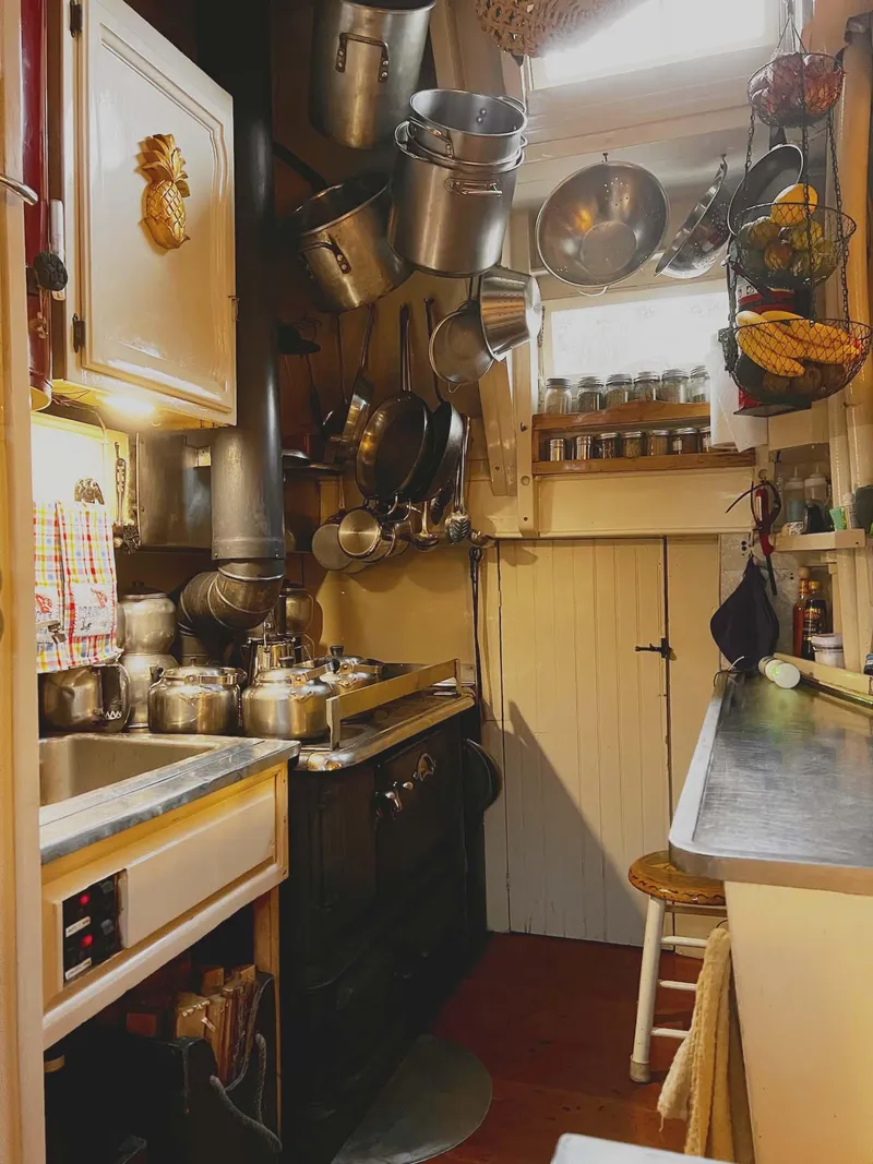 Slide: The Image of Cozy kitchen with hanging pots, vintage stove, and spices in a 1962 Gamage schooner. - 32