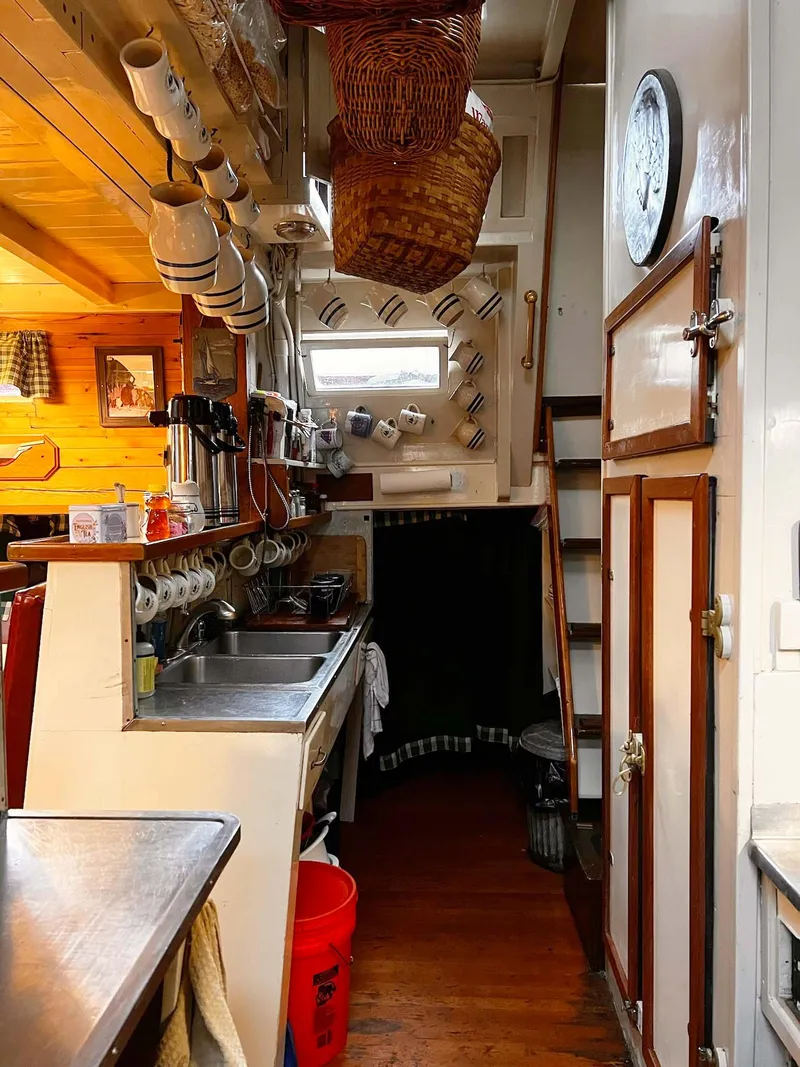 Slide: The Image of Interior of 1962 Gamage Coastal Gaff Rigged Schooner with cozy kitchen and wooden decor. - 35