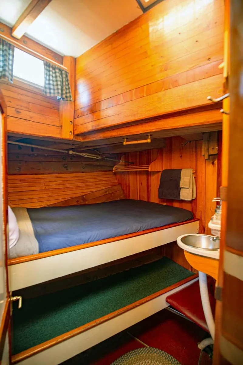 Slide: The Image of Cozy wooden cabin interior of 1962 Gamage Coastal Gaff Rigged Schooner with bed and sink. - 41