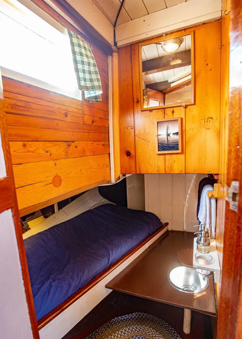 Slide: The Image of Cozy cabin interior of 1962 Gamage Coastal Gaff Rigged Schooner with wooden paneling and small sink. - 42