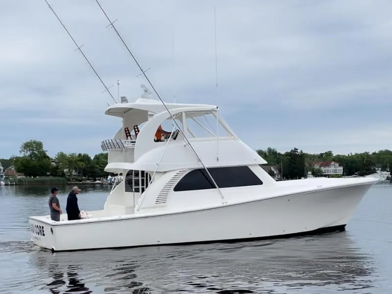 The Image of 2021 Henriques 50 Sportfisherman boat cruising on a calm waterway. - 0