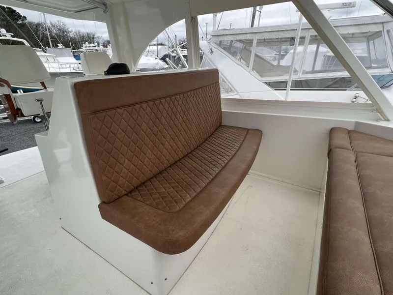 Slide: The Image of Henriques 50 Sportfisherman 2021 interior with brown leather seating and white deck. - 18