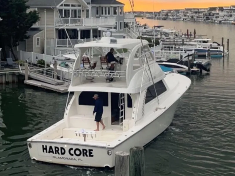 Slide: The Image of 2021 Henriques 50 Sportfisherman Hard Core docked in a marina at sunset. - 2