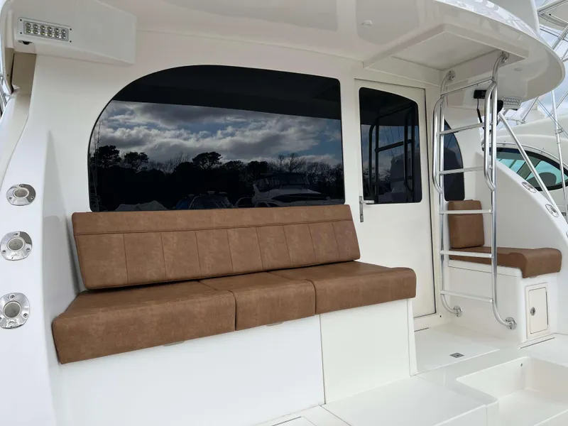 Slide: The Image of 2021 Henriques 50 Sportfisherman boat with brown cushioned seating and ladder. - 5