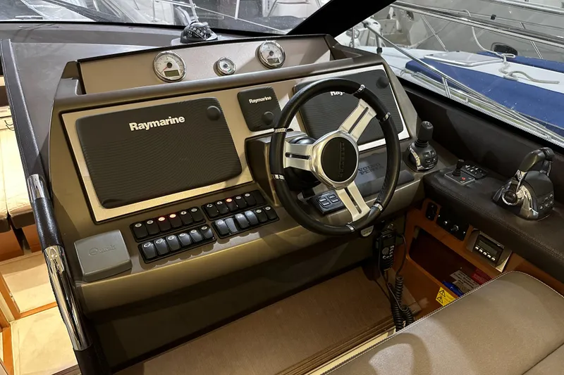 Slide: The Image of Prestige 500 yacht helm station with Raymarine navigation system, steering wheel, and control panel, 2013 model. - 13