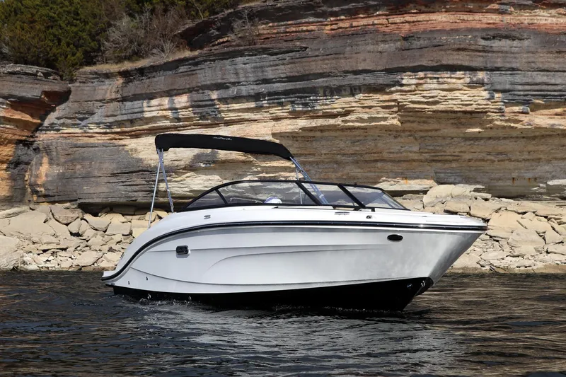 Slide: The Image of 2024 Sea Ray SPX 210 boat cruising near rocky shoreline. - 3