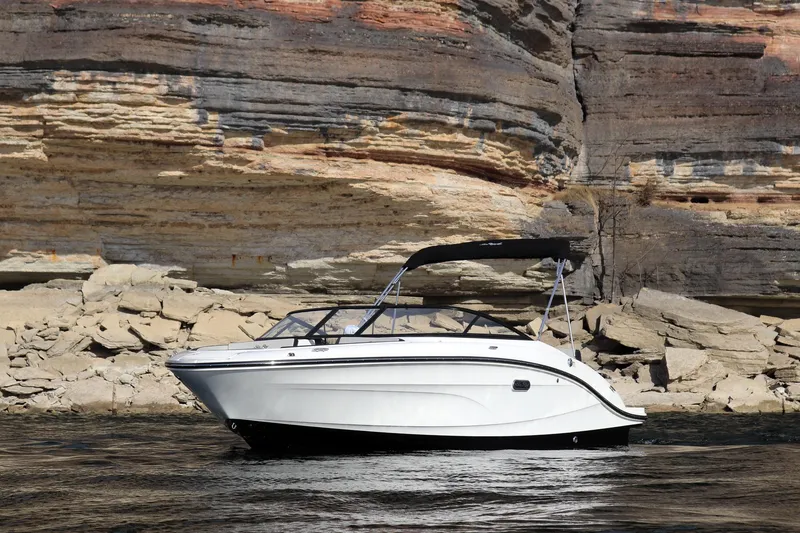 Slide: The Image of 2024 Sea Ray SPX 210 boat cruising near rocky shoreline. - 5