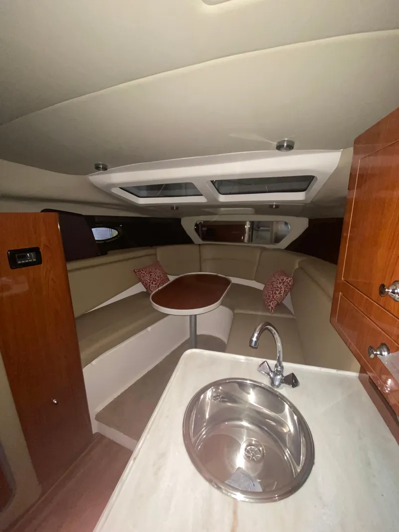 Slide: The Image of Interior of 2012 Regal 3060 Express Cruiser with kitchenette and seating area. - 20