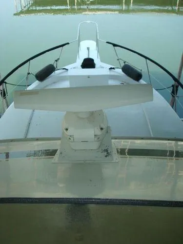 Slide: The Image of 1988 Chris-Craft Constellation boat deck with radar, docked on calm water. - 10