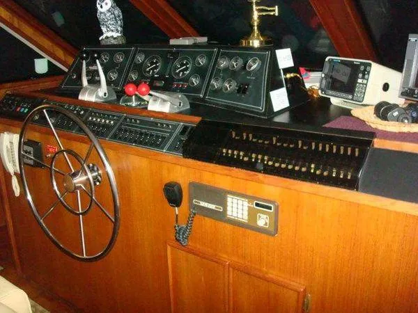 Slide: The Image of 1988 Chris-Craft Constellation helm with classic wooden dashboard and navigation instruments. - 12