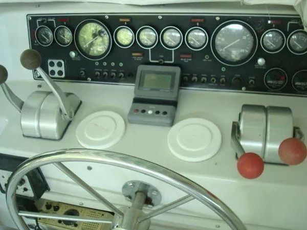Slide: The Image of 1988 Chris-Craft Constellation boat dashboard with gauges, controls, and steering wheel. - 2