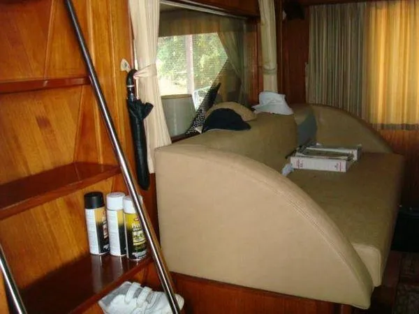 Slide: The Image of 1988 Chris-Craft Constellation interior with wooden shelves and beige seating. - 21