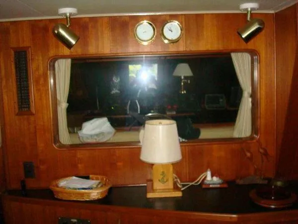 Slide: The Image of 1988 Chris-Craft Constellation yacht interior with wood paneling, window, and nautical decor. - 22