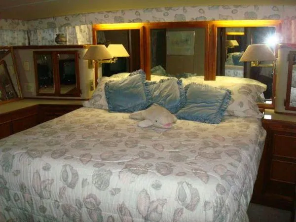 Slide: The Image of Luxurious bedroom interior of 1988 Chris-Craft Constellation yacht with plush bedding and elegant decor. - 38