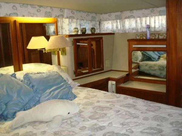 Slide: The Image of Luxurious 1988 Chris-Craft Constellation yacht bedroom with plush bedding and elegant wood accents. - 40