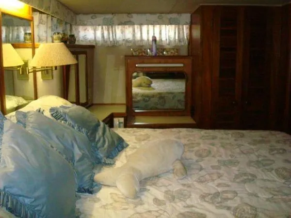 Slide: The Image of Bedroom interior of 1988 Chris-Craft Constellation yacht with plush bedding and wooden furnishings. - 42