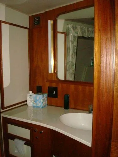 Slide: The Image of 1988 Chris-Craft Constellation bathroom with wooden cabinetry and a white countertop. - 45