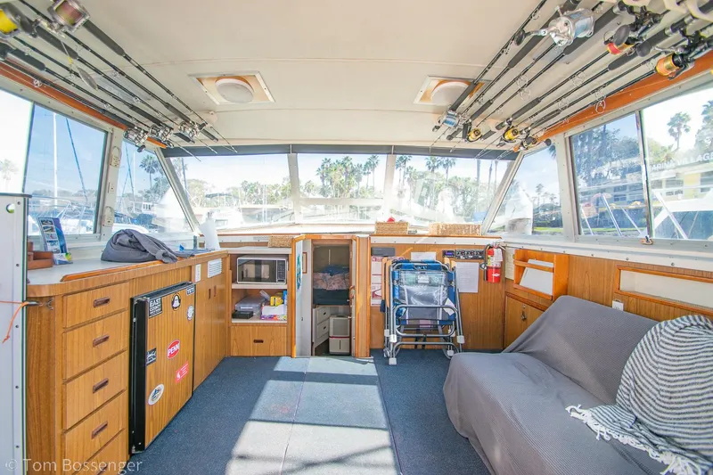 Slide: The Image of Interior of a 1976 Bertram 35 Convertible boat with fishing rods and cozy seating. - 10