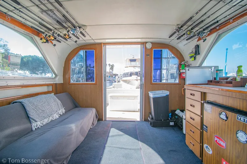 Slide: The Image of Interior of a 1976 Bertram 35 Convertible boat with fishing rods and cozy seating. - 18