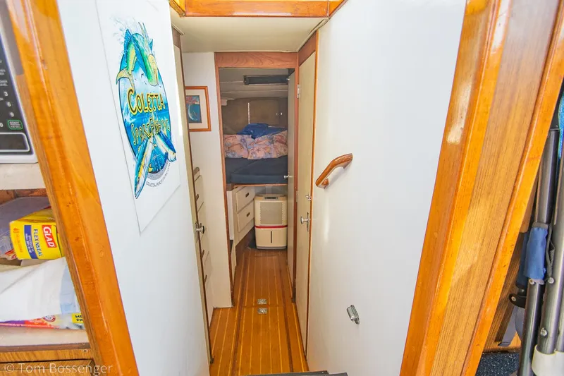 Slide: The Image of Interior hallway of a 1976 Bertram 35 Convertible boat with wooden flooring. - 20