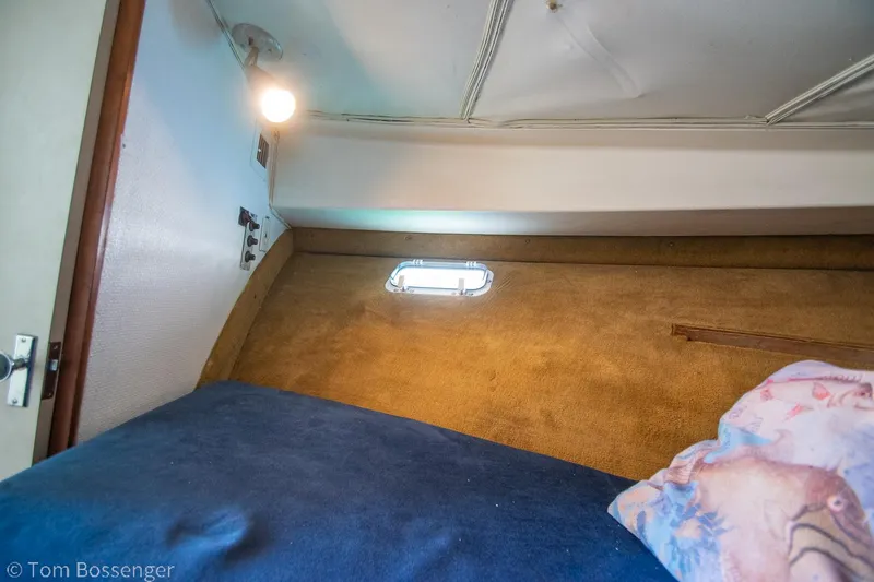 Slide: The Image of 1976 Bertram 35 Convertible cabin interior with bed, light, and small window. - 23