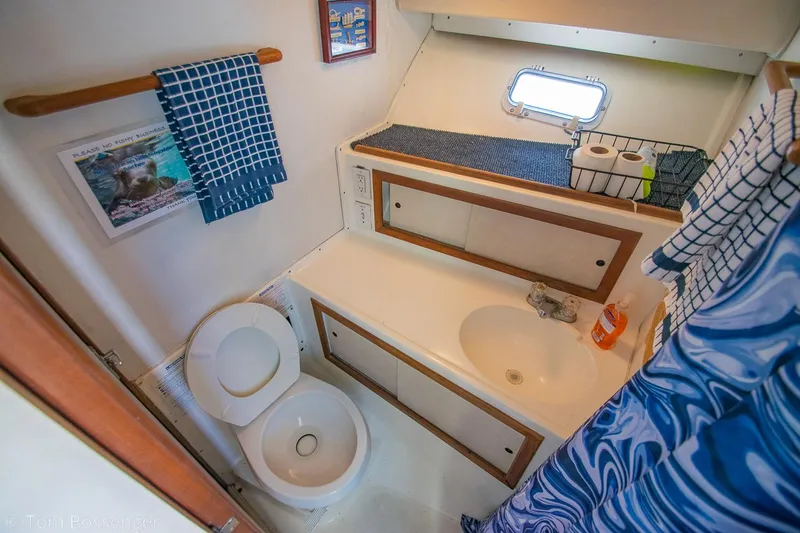 Slide: The Image of 1976 Bertram 35 Convertible bathroom with toilet, sink, and nautical decor. - 25