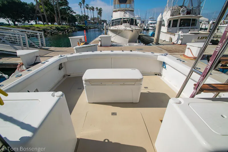 Slide: The Image of 1976 Bertram 35 Convertible boat deck with seating and storage, docked at a marina. - 26