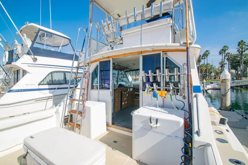 Slide: The Image of 1976 Bertram 35 Convertible yacht docked at marina, featuring fishing equipment and spacious deck. - 9