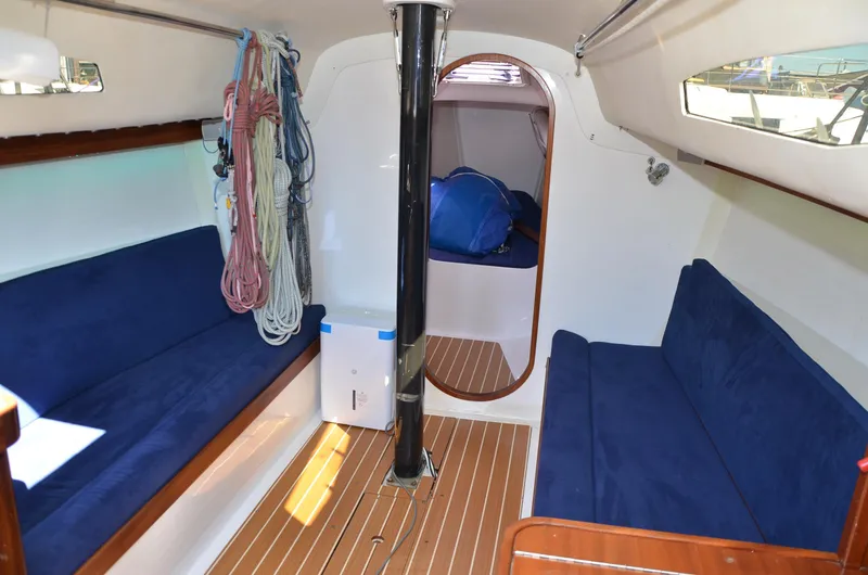 Slide: The Image of Interior of 2011 J Boats J/111 sailboat with blue seating and wooden flooring. - 16