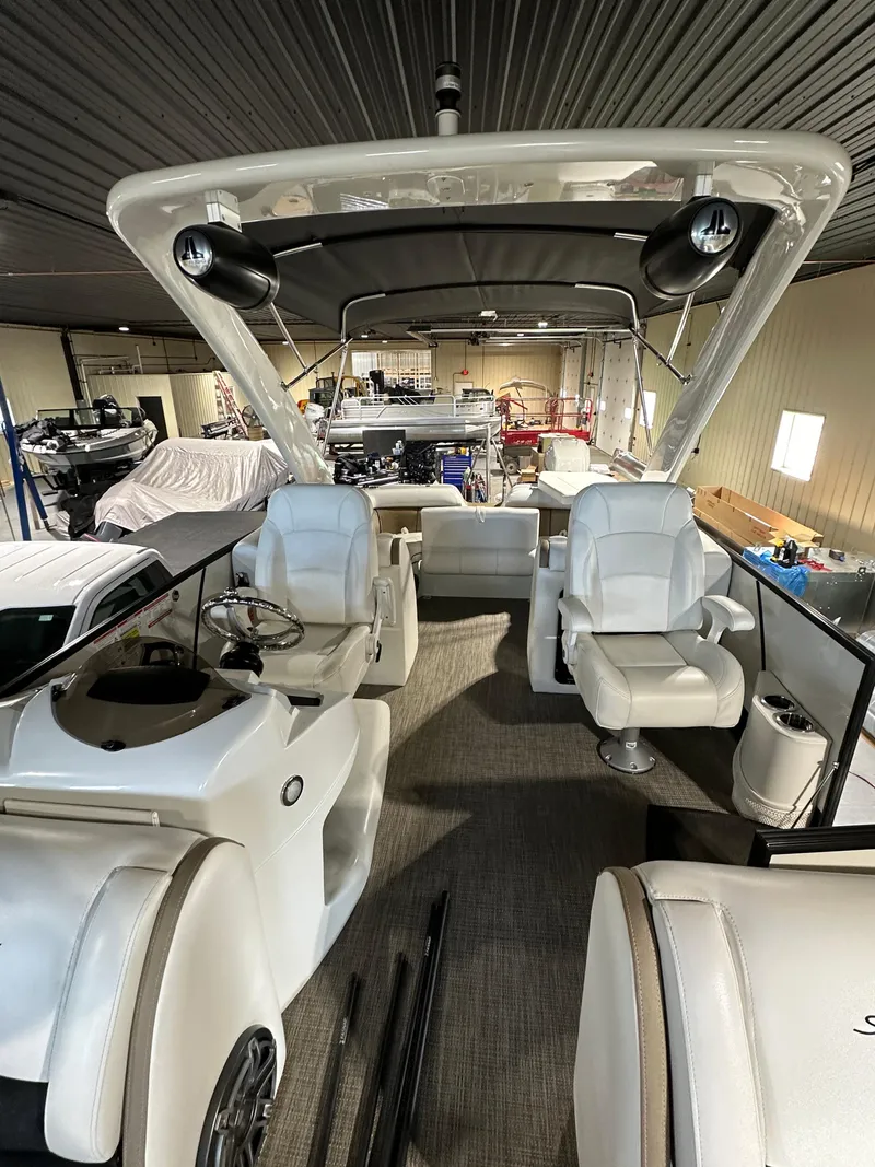 Slide: The Image of 2019 South Bay 25SPORT CR9 3.0 pontoon boat interior with white seating and helm. - 11