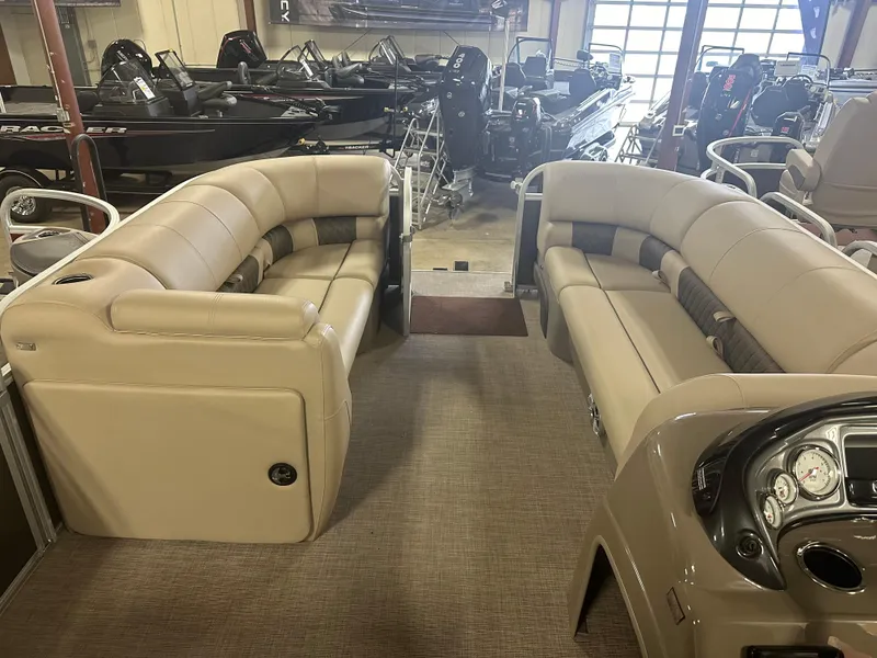 Slide: The Image of 2023 Sun Tracker Party Barge 20 DLX interior with beige seating in showroom. - 2