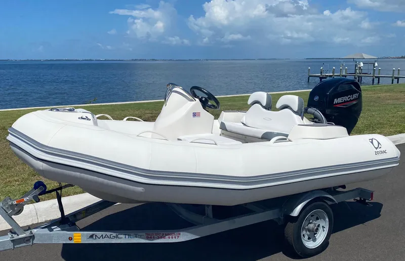 The Image of 2024 Zodiac Yachtline 360 inflatable boat on trailer by the waterfront. - 0