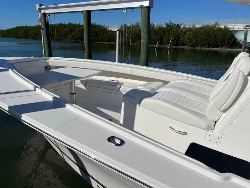 Slide: The Image of 2024 Regulator 41 boat with white seating, docked near a serene waterway. - 11