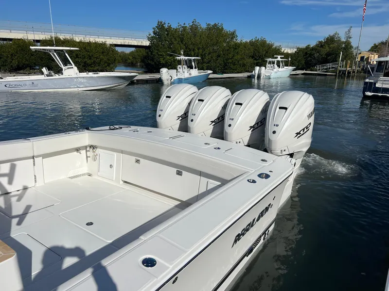 Slide: The Image of 2024 Regulator 41 boat with four powerful outboard engines on a calm waterway. - 13