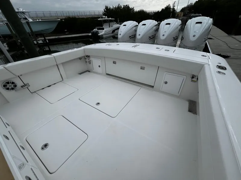 Slide: The Image of 2024 Regulator 41 boat deck with storage compartments and quad outboard engines. - 18