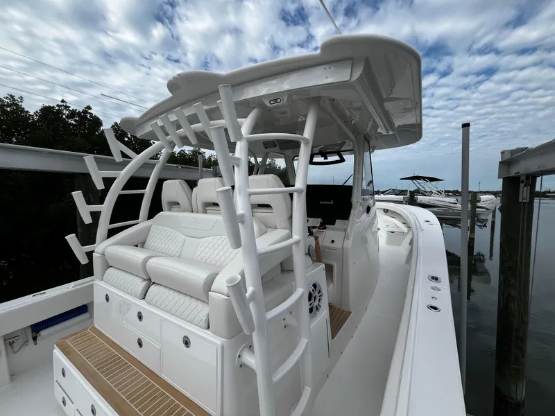 Slide: The Image of 2024 Regulator 41 boat with white seating and sleek design docked by the water. - 23