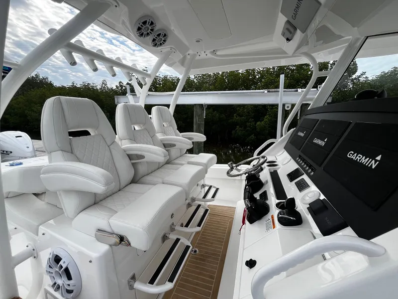 Slide: The Image of 2024 Regulator 41 boat cockpit with white seating and Garmin navigation system. - 27