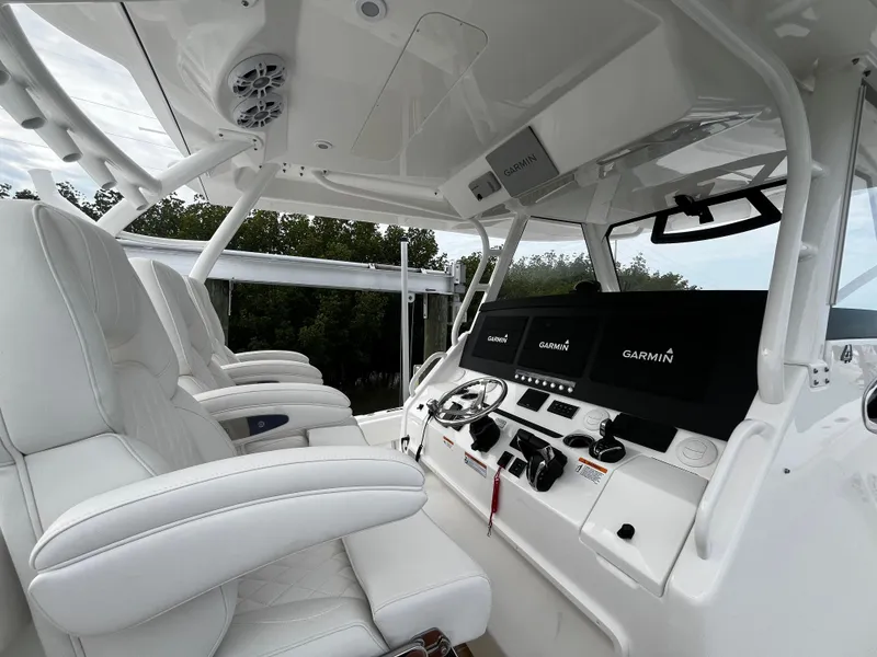 Slide: The Image of 2024 Regulator 41 boat cockpit with white leather seats and Garmin navigation system. - 28