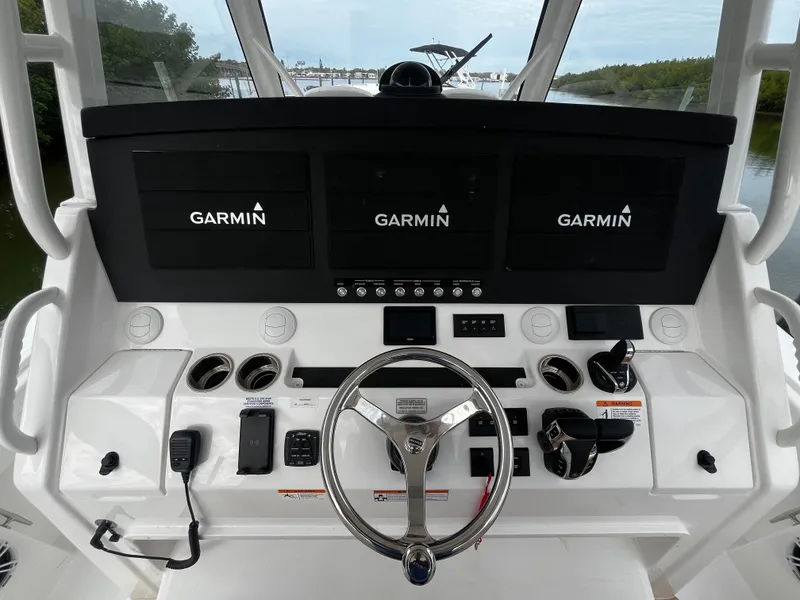 Slide: The Image of 2024 Regulator 41 boat helm with Garmin navigation screens and controls. - 30