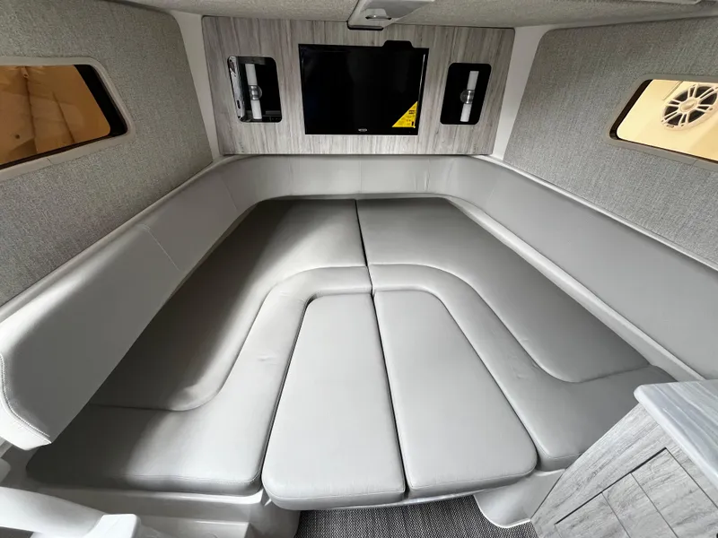 Slide: The Image of 2024 Regulator 41 boat interior cabin with grey seating and mounted TV. - 38