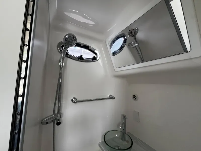 Slide: The Image of 2024 Regulator 41 boat bathroom with shower, mirror, and sink. - 43